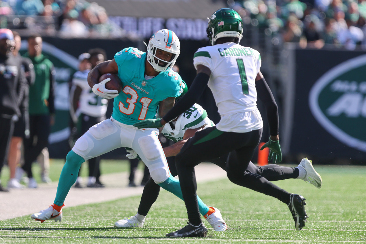 Dolphins' RB Raheem Mostert runs at Jets' CB Sauce Gardner